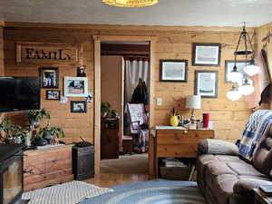 Interior space featuring wood-type flooring, a textured ceiling, and wood walls