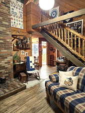 Living room featuring hardwood / wood-style flooring, a towering ceiling, and wooden walls