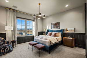 Carpeted bedroom featuring a mountain view and a notable chandelier