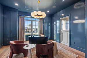 Office space with hardwood / wood-style flooring and an inviting chandelier