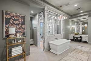 Bathroom featuring vanity, crown molding, tile patterned floors, and a bathing tub