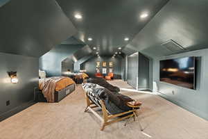 Bedroom with lofted ceiling and light carpet