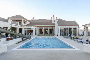 Back of house with a balcony and a patio