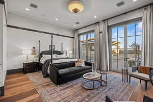 Bedroom featuring french doors, ornamental molding, light hardwood / wood-style flooring, and access to outside