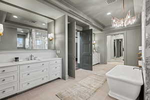 Bathroom with vanity, a raised ceiling, and tile patterned flooring