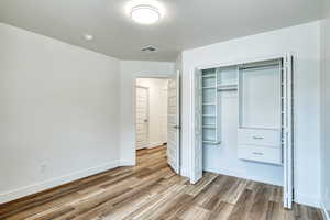 Unfurnished bedroom featuring hardwood / wood-style flooring and a closet