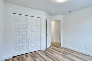 Unfurnished bedroom featuring light hardwood / wood-style floors and a closet