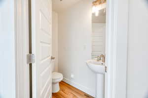 Bathroom featuring sink, hardwood / wood-style floors, and toilet