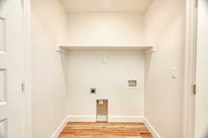 Laundry room with hookup for a washing machine, electric dryer hookup, and light hardwood / wood-style floors