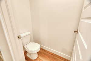 Bathroom with hardwood / wood-style flooring and toilet