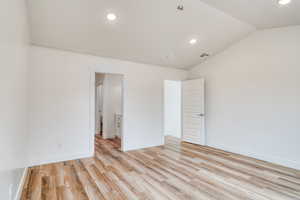 Unfurnished room with lofted ceiling and light wood-type flooring