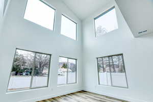 Empty room featuring a high ceiling and light wood-type flooring