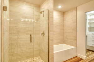 Bathroom featuring wood-type flooring and separate shower and tub