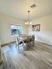 Dining area featuring hardwood / wood-style floors and a notable chandelier