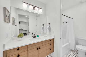 Full bathroom with vanity, toilet, and shower / bath combo with shower curtain