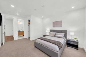 Carpeted bedroom featuring ensuite bath