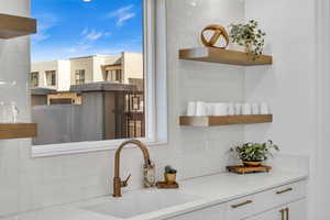 Kitchen featuring white cabinetry, sink, and backsplash