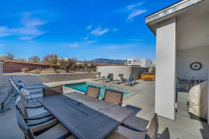 View of patio with a swimming pool with hot tub and a mountain view