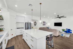 Kitchen with white cabinetry, stainless steel appliances, and a center island