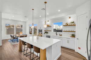 Kitchen with sink, tasteful backsplash, a center island, stainless steel appliances, and white cabinets