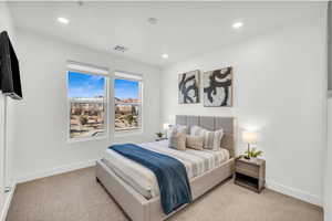 Bedroom featuring light colored carpet