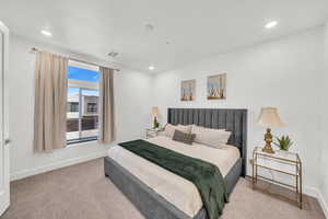 Bedroom featuring light carpet