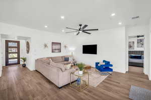 Living room with ceiling fan and light wood-type flooring