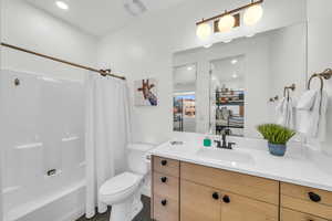 Full bathroom with shower / tub combo, vanity, and toilet