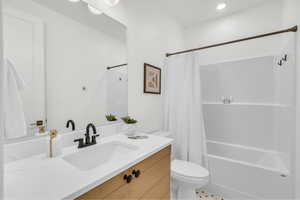 Full bathroom with vanity, toilet, and shower / bath combo with shower curtain