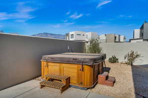 View of patio with a hot tub and a mountain view