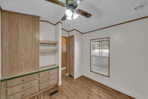 Unfurnished bedroom featuring crown molding, light hardwood / wood-style flooring, and ceiling fan