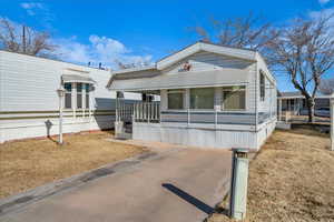 Manufactured / mobile home with a porch and a front lawn