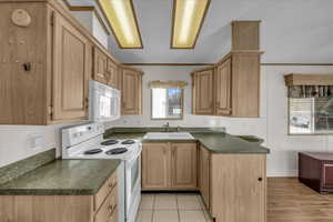 Kitchen featuring white appliances, ornamental molding, sink, and light brown cabinets