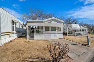 Manufactured / mobile home with a porch and a front lawn