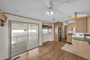 Kitchen with light brown cabinetry, ceiling fan, crown molding, white appliances, and light hardwood / wood-style flooring