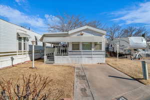 Manufactured / mobile home with a front yard and covered porch