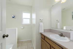 Bathroom featuring vanity, a tub to relax in, and tile patterned flooring