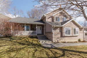 View of front of property with a porch and a front yard