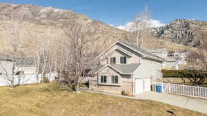 Front of property with a garage, a mountain view, and a front yard