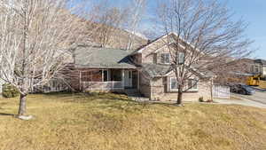 View of front facade with covered porch and a front yard