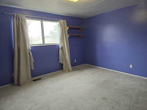 Carpeted empty room featuring a textured ceiling