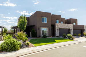 Pueblo-style home featuring a front yard