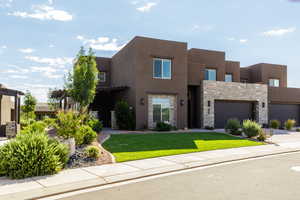 Pueblo-style house featuring a front yard