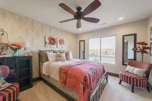 Carpeted bedroom featuring ceiling fan