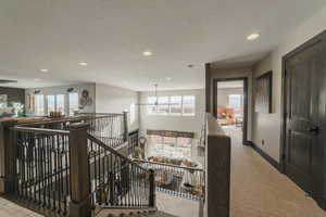 Corridor with carpet floors and a textured ceiling