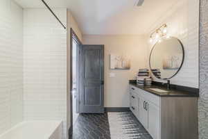 Bathroom featuring vanity, tile patterned floors, and  shower combination