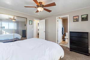 Bedroom with ensuite bathroom, light carpet, a textured ceiling, a closet, and ceiling fan