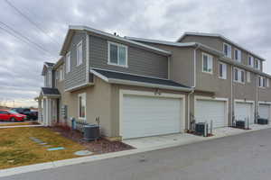 Exterior space featuring cooling unit and a garage