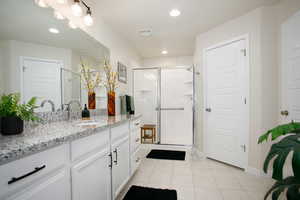 Bathroom with vanity, tile patterned floors, and a shower with shower door