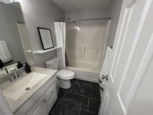 Full bathroom featuring tile patterned floors, toilet, a textured ceiling, vanity, and shower / bath combination with curtain